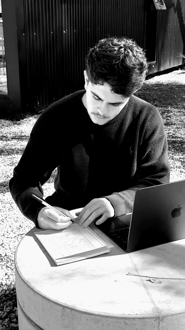 Socio de MOTIF tomando notas junto a su notebook, al aire libre